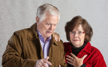angry man using tablet with embarrassed woman