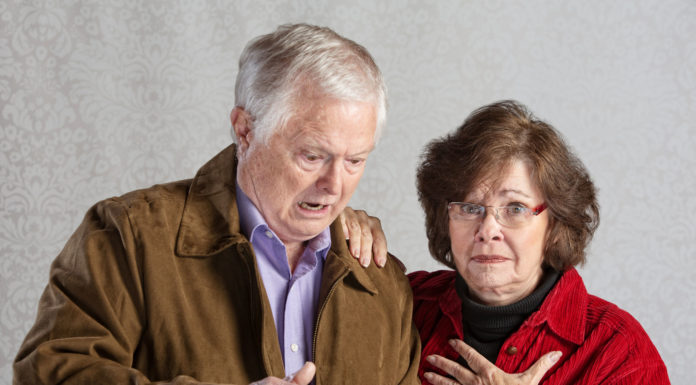 angry man using tablet with embarrassed woman