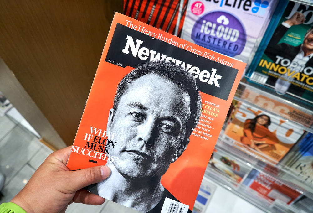 Elon musk Newsweek magazine in a hand.